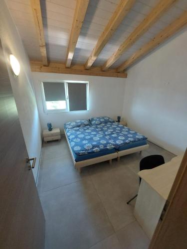 a bedroom with a bed and a desk in it at Chambres de la Tuilerie in Saignelégier