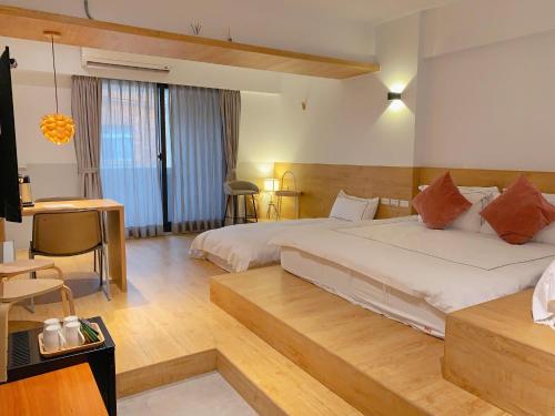 duża sypialnia z 2 łóżkami i biurkiem w obiekcie 法格洛絲文旅 w mieście Beipu