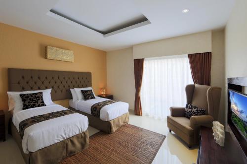 una camera d'albergo con due letti e una TV a schermo piatto di Flamingo Dewata Pool Villa Uluwatu a Uluwatu