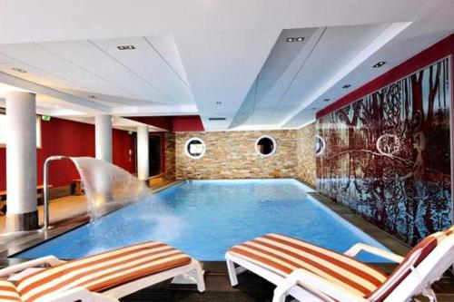 - une grande piscine dans une pièce avec 2 chaises dans l'établissement Magnifique T4 pied des pistes, à Risoul