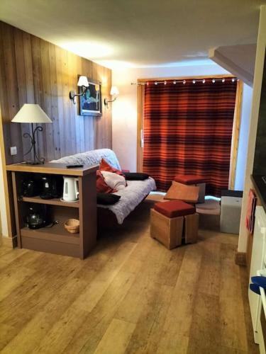 Cette chambre comprend un lit et un bureau avec une fenêtre. dans l'établissement Magnifique T4 pied des pistes, à Risoul