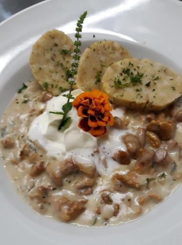 a white bowl of soup with beans and mushrooms at Dolomitenhotel Lienz in Lienz