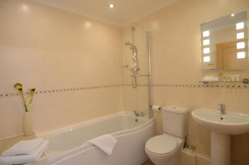 a bathroom with a tub and a toilet and a sink at Bell Country Inn in Llanyre