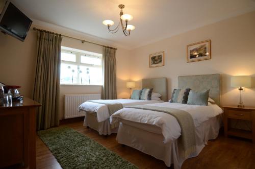 a bedroom with two beds and a window at Bell Country Inn in Llanyre