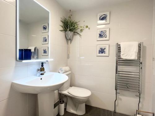 bagno bianco con lavandino e servizi igienici di Après Beach Apartment Sleeps 4 Penzance a Penzance