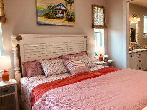 um quarto com uma cama e um quadro na parede em Coastal Cottage at Naples Bay em Naples