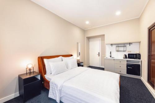 a bedroom with a white bed and a kitchen at Salve in Tbilisi City