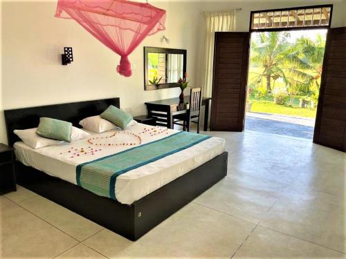 a bedroom with a large bed in a room at Suwetha villa Ayurveda Resort in Bentota