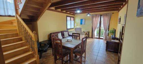 a dining room with a table and chairs and a staircase at Apartamentos Rurales Argame in Argamé