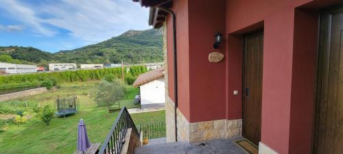 a house with a balcony with a view of a mountain at Apartamentos Rurales Argame in Argamé