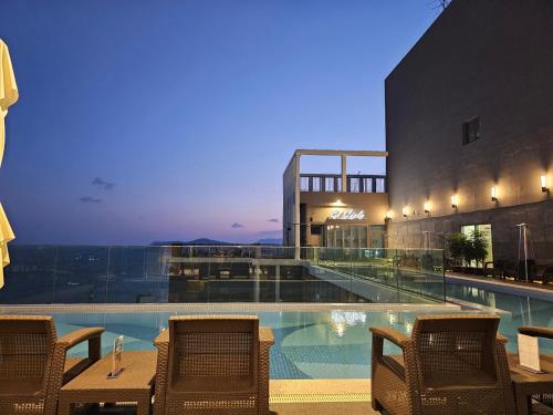 a hotel swimming pool with chairs and a building at ELBON the stay Haeundae beach in Busan