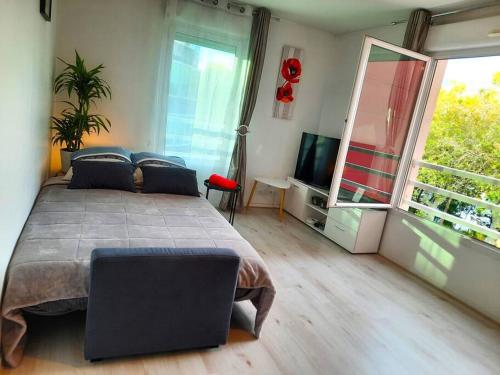 a bedroom with a large bed and a large window at Vue panoramique Sur la Seine - 5' Tram - Direct Paris - Parking - Netflix in Bezons