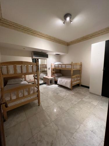 a bedroom with two bunk beds and a tile floor at The GlassHouse Pool in Cairo
