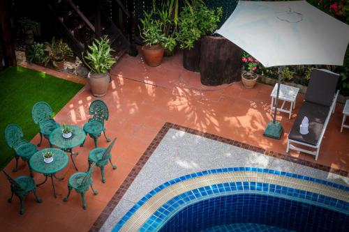 an overhead view of a pool with tables and chairs and an umbrella at Chandara Boutique Hotel in Vientiane