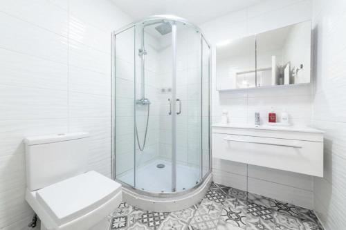 a white bathroom with a shower and a toilet at Spacious Double Bed With Sofa Bed In Isleworth TW7 in Isleworth
