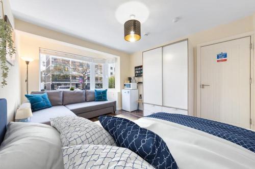 sala de estar con 2 camas y sofá en Spacious Double Bed With Sofa Bed In Isleworth TW7 en Isleworth