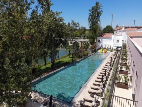 an overhead view of a swimming pool with lounge chairs and trees at Vila Gale Collection Tomar in Tomar