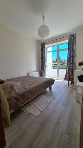 - une chambre avec un grand lit et une grande fenêtre dans l'établissement Spacious Condo 5 min to Jurmala Beach, à Jurmala