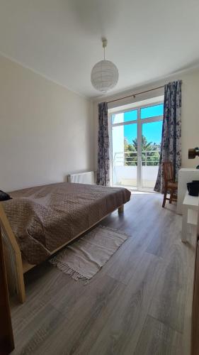 ユールマラにあるSpacious Condo 5 min to Jurmala Beachのベッドルーム(大型ベッド1台、大きな窓付)