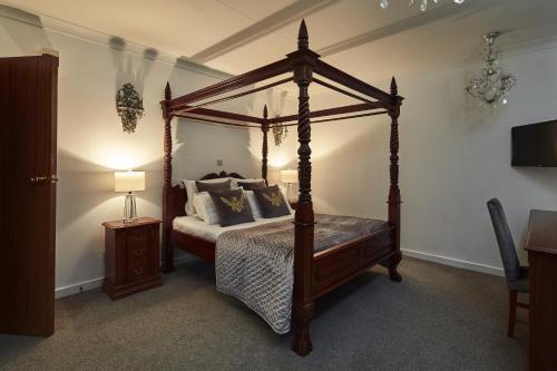 a bedroom with a canopy bed with pillows on it at The Pyewipe in Lincoln