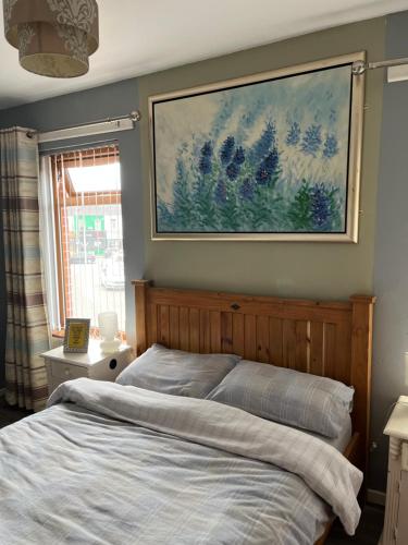 um quarto com uma cama e um quadro na parede em 11 Parkmore Street, Ormeau Road, Belfast, BT7 2GT, 2 bedroom House em Belfast