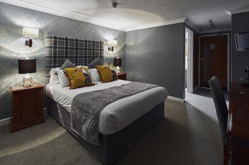 sypialnia z dużym łóżkiem z żółtymi poduszkami w obiekcie The Pyewipe w mieście Lincoln
