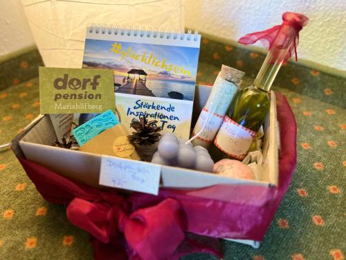 a gift basket with a bottle of wine and other items at Dorfpension Mariahilfberg in Gutenstein