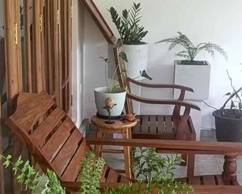 a porch with a wooden bench and potted plants at Tranquil at Airport Reach in Gonawala