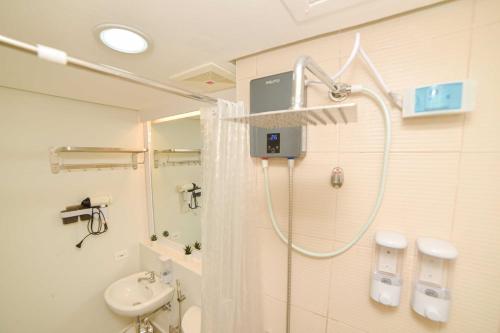a bathroom with a shower and a sink at RcplacePH at Pinesuites Tagaytay in Tagaytay