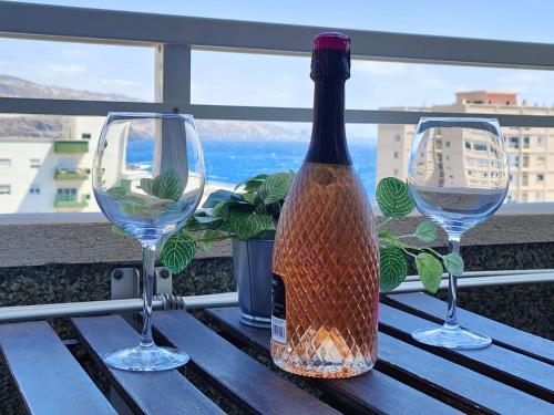 a bottle of wine sitting on a table with two glasses at Vacacional Candelaria vistas al mar con garaje gratuito in Candelaria