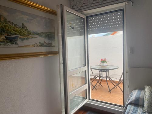 a room with a sliding glass door with a table and a window at Rincón de Cantabria 1 in Santoña