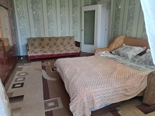 sypialnia z łóżkiem i kanapą w obiekcie Dacia w Kiszyniowie