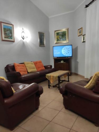 a living room with couches and a flat screen tv at Domus de Daan in Porto Alabe
