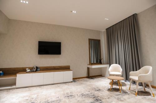 a living room with two chairs and a tv on the wall at PREMIER HOTEL in Andijan