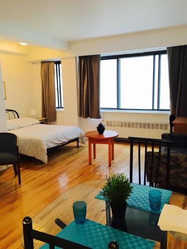 een woonkamer met een bed en een tafel bij Stylish Montreal Apartment: Comfortable Stay in the Golden Square Mile in Montreal