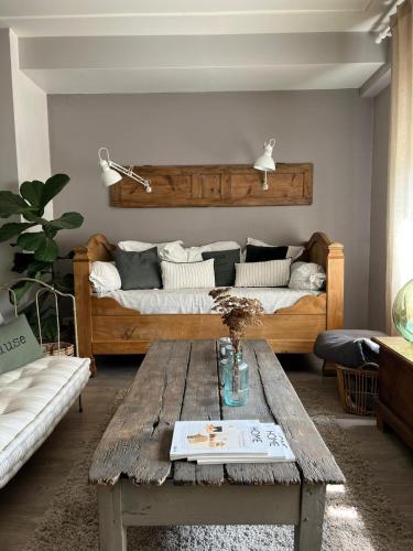 sala de estar con 2 camas y mesa de madera en les chambres de pauline, en Albertville