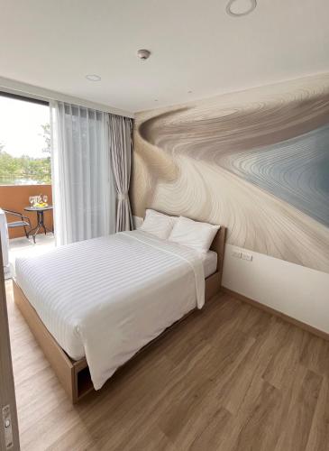 sypialnia z łóżkiem z obrazem na ścianie w obiekcie Sky Park Laguna 1bdr Lake View w mieście Thalang
