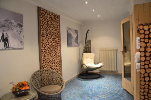 Zimmer mit 2 Stühlen, einem Stuhl und einem Spiegel in der Unterkunft Waldheim in Sulden