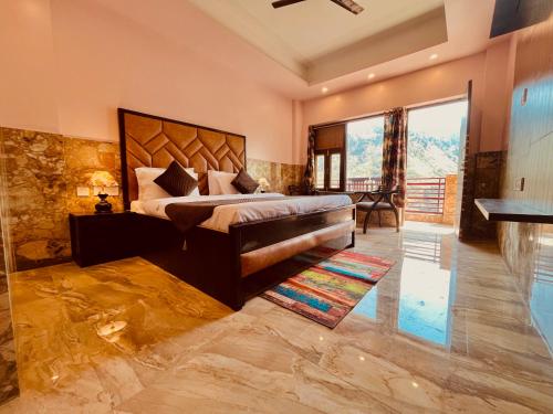 a bedroom with a large bed and a large window at River Grand Resort - A Peaceful Stay Kempty Fall Mussoorie in Mussoorie