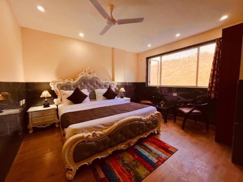 - une chambre avec un grand lit et une grande fenêtre dans l'établissement River Grand Resort - A Peaceful Stay Kempty Fall Mussoorie, à Mussoorie
