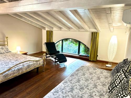 - une chambre avec un lit, une chaise et une fenêtre dans l'établissement La Corte di Saronno, à Saronno