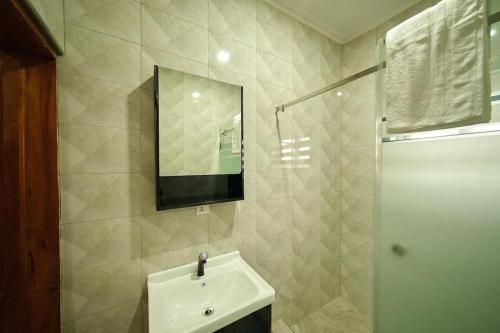 ein Bad mit einem Waschbecken und einem Spiegel in der Unterkunft Kayla's Court Apartments in Accra