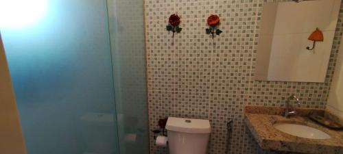 a bathroom with a toilet and a sink and a shower at Pousada Sitio das Flores 12 km de Macacos Nova Lima in Nova Lima