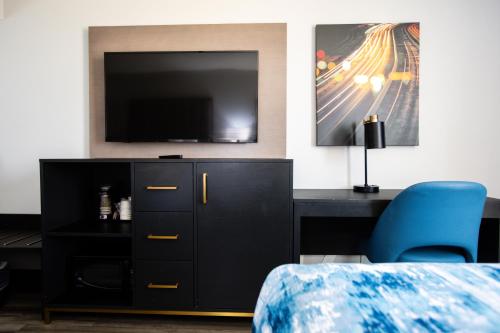 a bedroom with a black dresser with a flat screen tv at La Quinta by Wyndham Dallas I-35 Walnut Hill Ln in Dallas