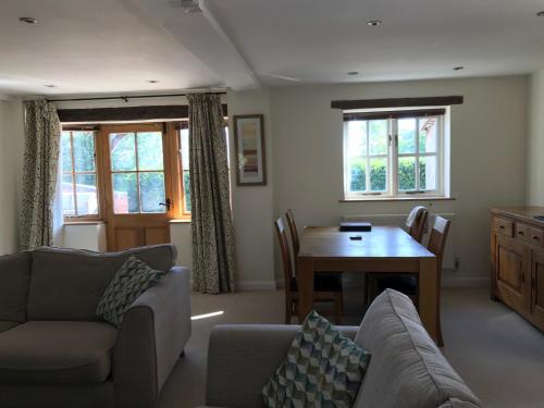 ein Wohnzimmer mit einem Sofa und einem Tisch in der Unterkunft The Stables Kenilworth in Kenilworth
