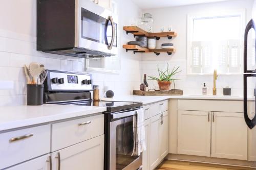 a kitchen with white cabinets and a black stove top oven at Sleeps 10! Minutes to Parris Island & Downtown in Beaufort