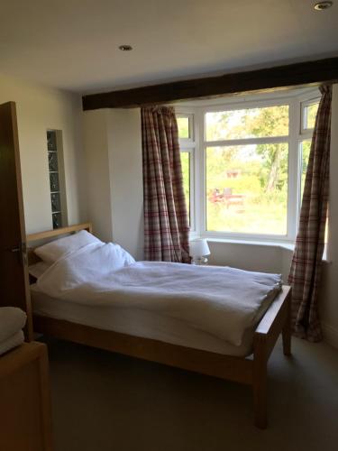 a bedroom with a bed and a large window at The Stables Kenilworth in Kenilworth
