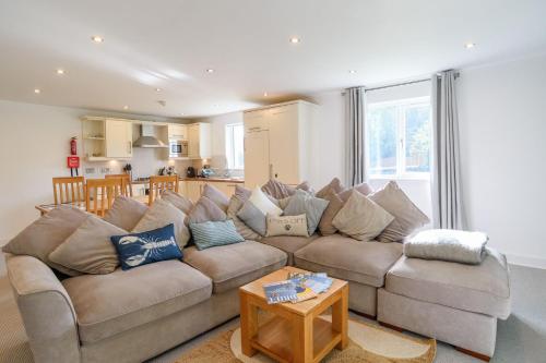 a living room with a large couch and a table at Trewhiddle 40 - A Luxury Cottage by Together Travel in St Austell