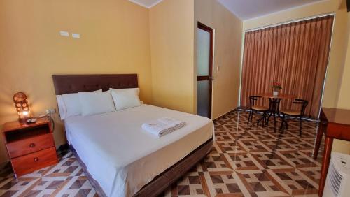 ティンゴ・マリアにあるLEMBRANÇAS HOTEL LODGEのベッドとテーブルが備わるホテルルームです。