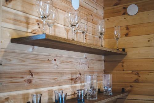 a row of wine glasses sitting on a shelf at Misty Rocks Kazbegi in Stepantsminda